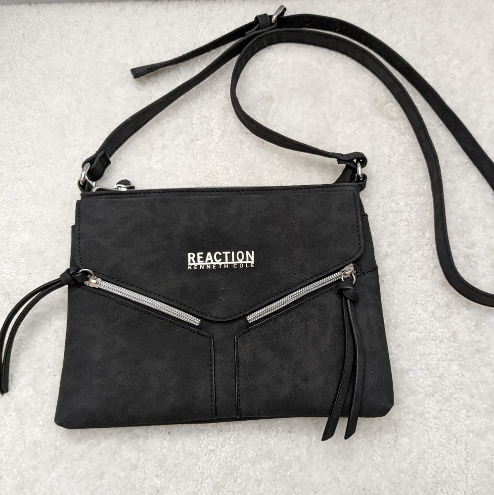Kenneth Cole Reaction skinny shoulder bag. Has two front tassel zippered pockets